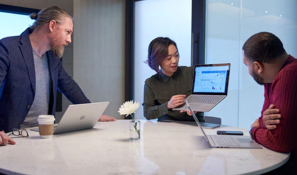 Business people in a meeting with their laptops accessing organisational applications protected by security tools