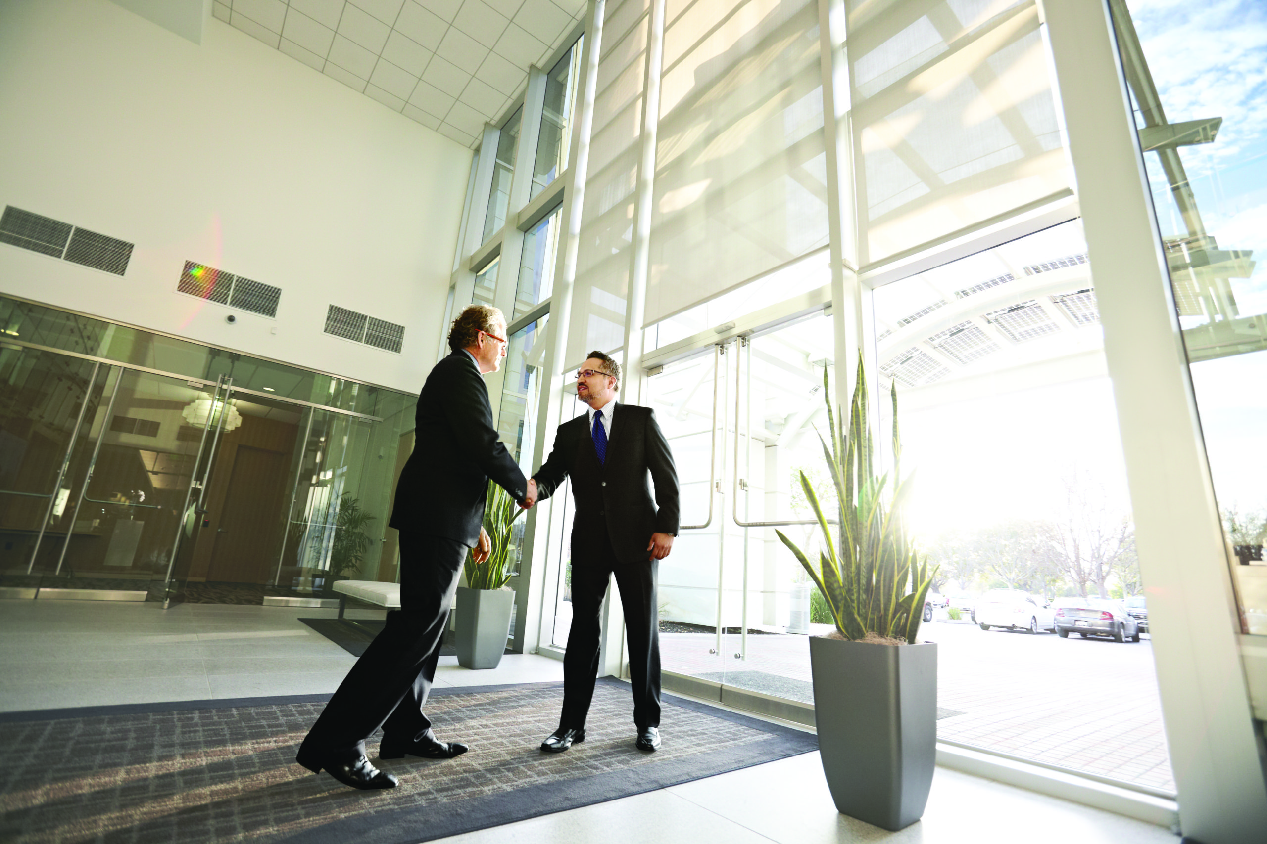 Businessmen shaking hands and IT partnerships for consultancy and advisory